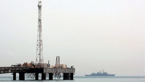 Warship patrolling the Persian Gulf near an oil platform